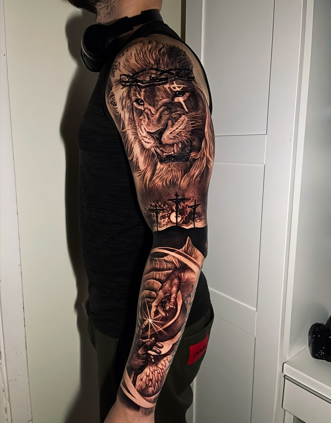 Hyper realism lion and crucifixion sleeve tattoo